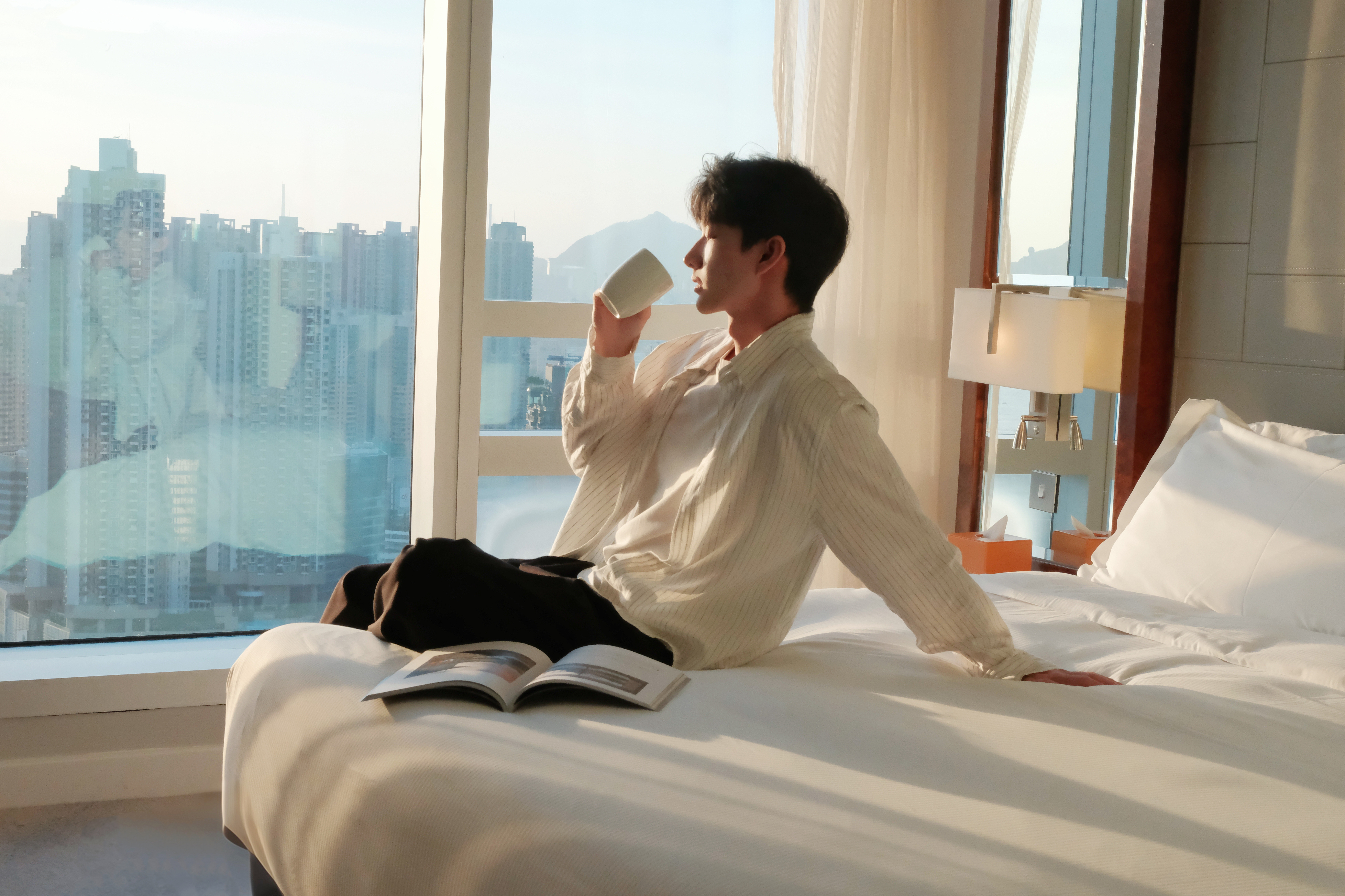 A couple staying at Cordis Hong Kong hotel in a room with harbour view